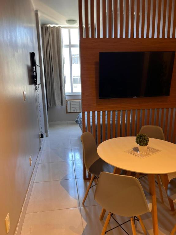 Habitación con mesa, sillas y TV. en Apartamento/Studio encantador no Posto 6 em Copa., en Río de Janeiro