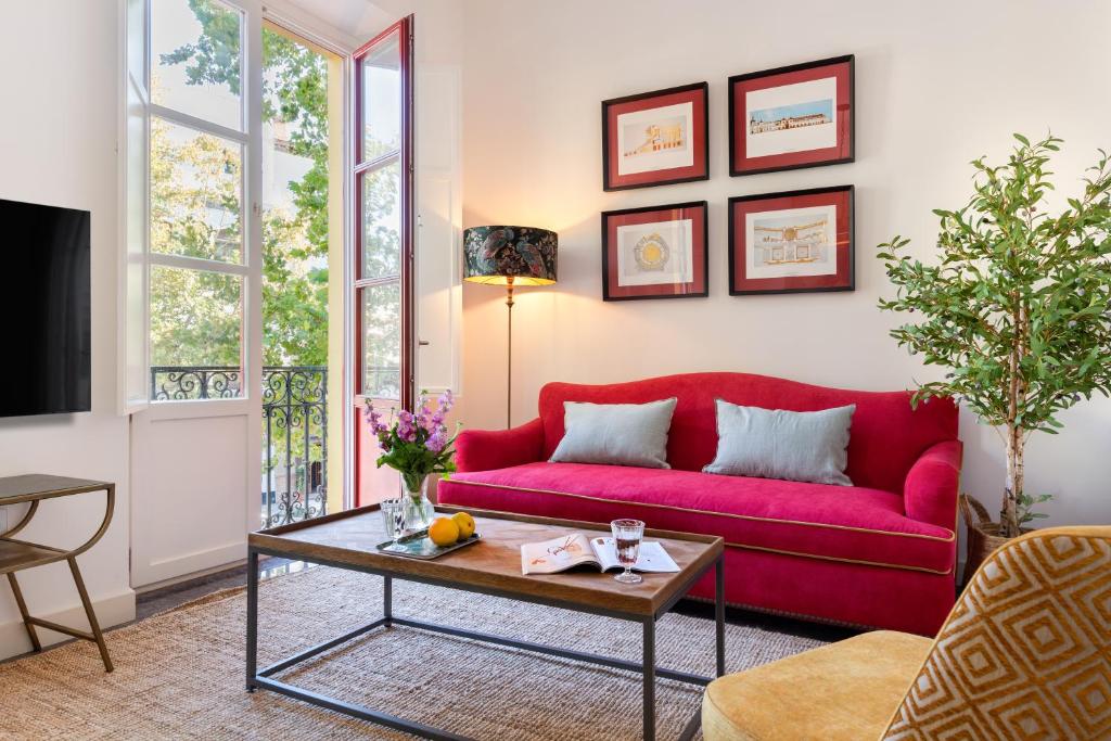 uma sala de estar com um sofá vermelho e uma mesa em Casas De Adriano em Sevilha