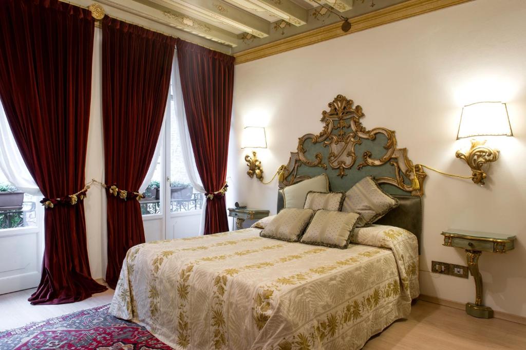 a bedroom with a large bed with red curtains at La Corte Di Giulietta in Verona