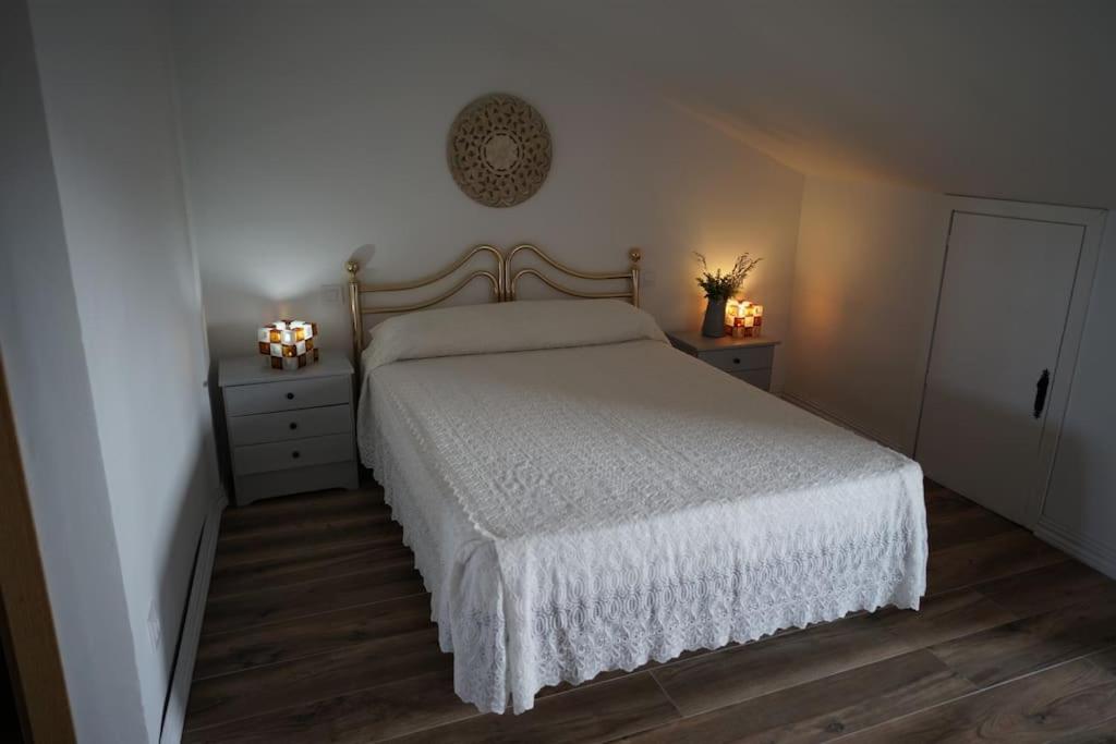a bedroom with a white bed and two night stands at Casa Rural Horizontes de la Mancha in El Toboso