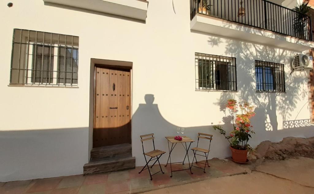 une terrasse avec une table et des chaises devant un bâtiment dans l'établissement Apartamento Alegría, à Frigiliana