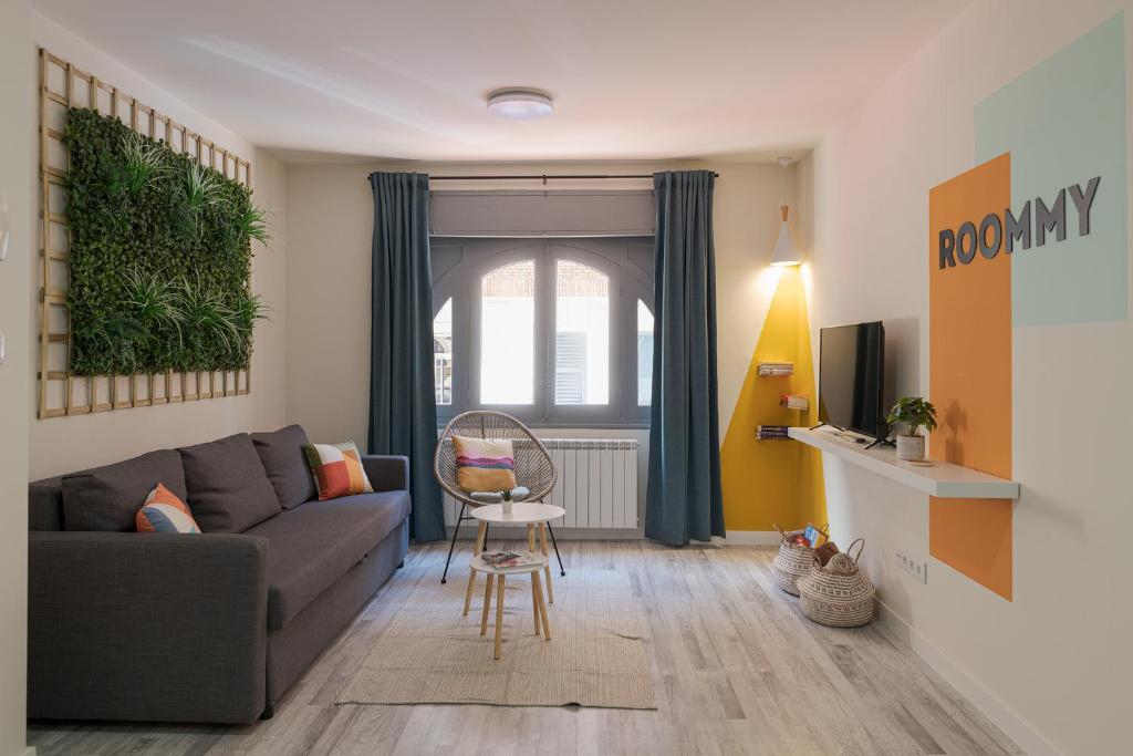 een woonkamer met een bank en een stoel bij ROOMMY in León