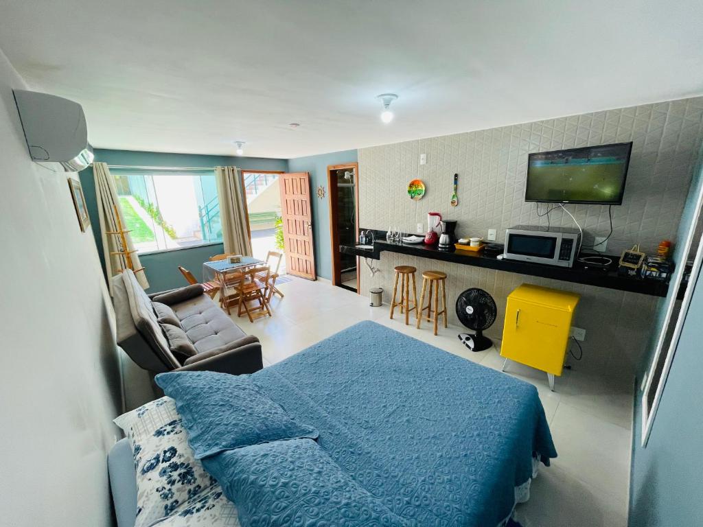 1 dormitorio con 1 cama azul y sala de estar en Morada do Mar Arraial do Cabo, en Arraial do Cabo