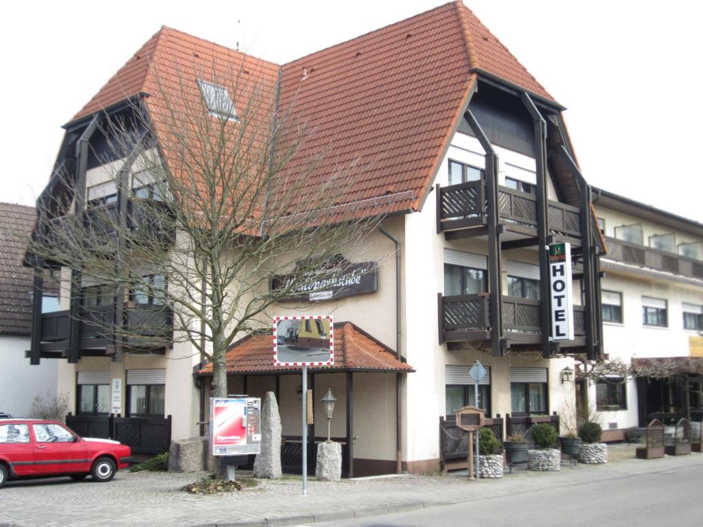 un bâtiment avec une voiture rouge garée devant lui dans l'établissement Hotel Waldparkstube, à Bad Schönborn