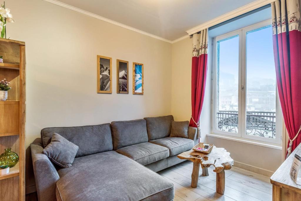 a living room with a couch and a large window at Cosy apartment in the center of Chamonix - Welkeys in Chamonix-Mont-Blanc