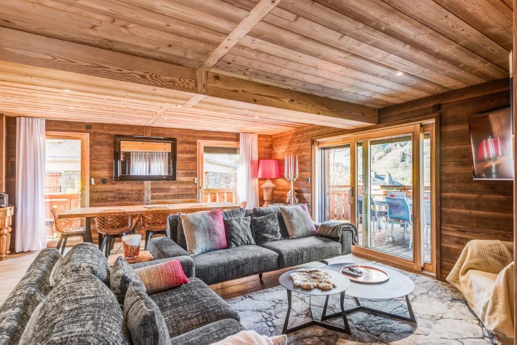 a living room with a couch and a table at Le Hameau des Cimes - Welkeys in Megève