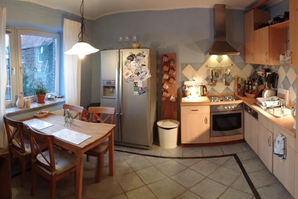 a kitchen with a table and a refrigerator at 2 BR beautyful vacation home / Ferienhaus Brunsberg in Buchholz in der Nordheide