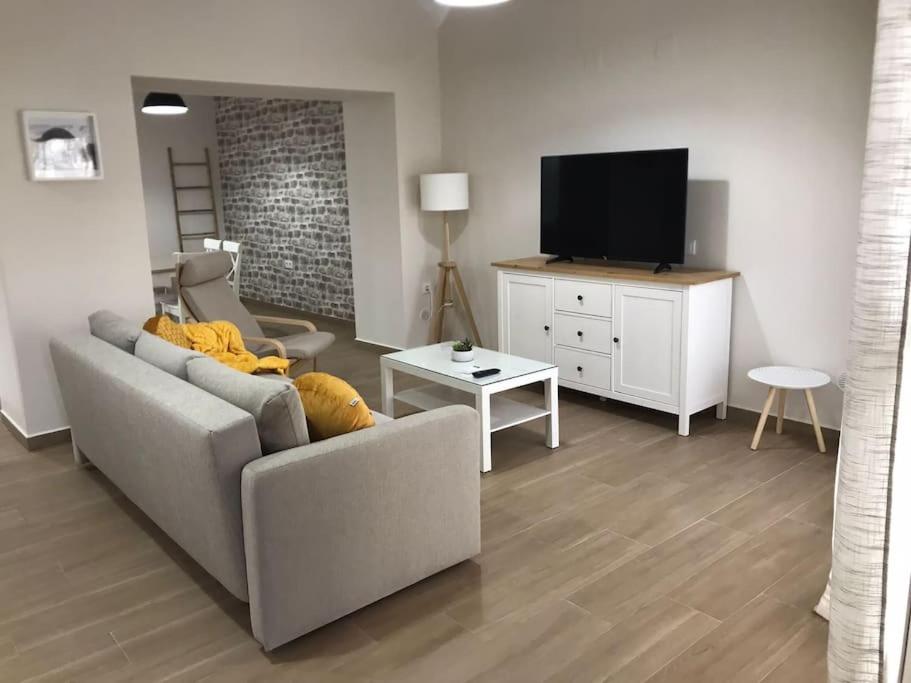 ein Wohnzimmer mit einem Sofa und einem TV in der Unterkunft Bonita y amplia casa con patio, en centro ciudad in Merida