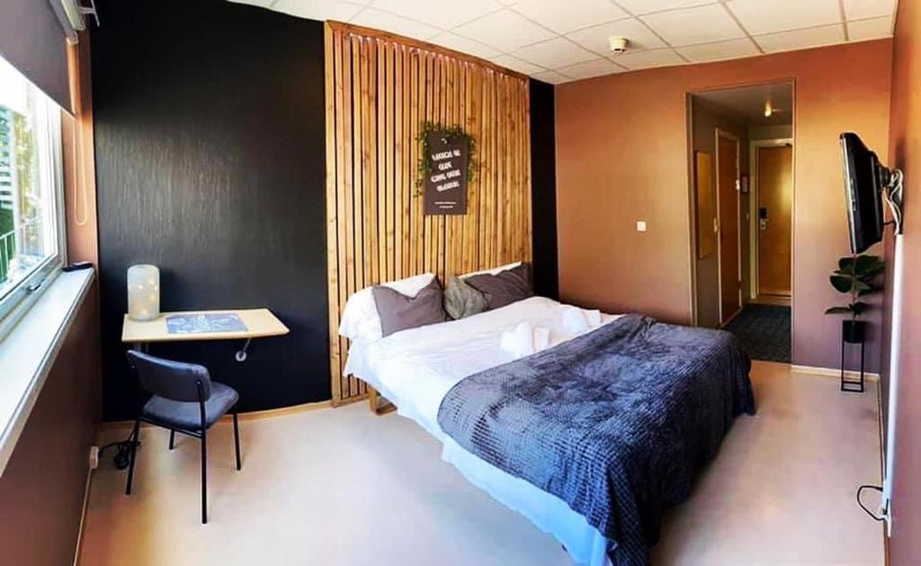 1 dormitorio con 1 cama, 1 mesa y 1 silla en Gjøvik Overnatting, en Gjøvik