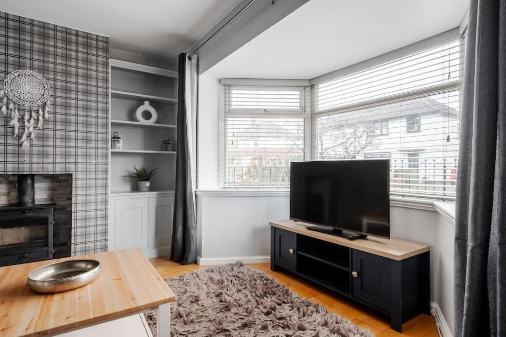 a living room with a television and a fireplace at Cressingham House Manchester in Manchester