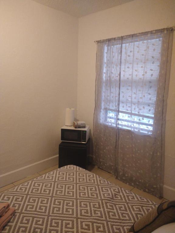 1 dormitorio con cama y ventana con cortina en cozy nice room, en San Petersburgo