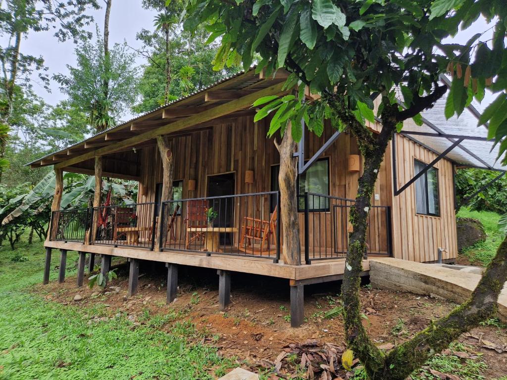 a cabin in the woods with a porch at Finca Amistad Cacao Lodge in Bijagua