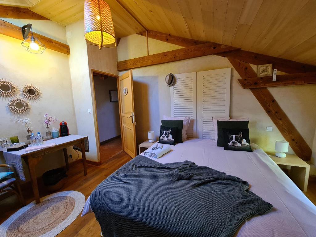 a bedroom with a large bed and a desk at Le Coq en Repos in Saint-Sylvestre-sur-Lot