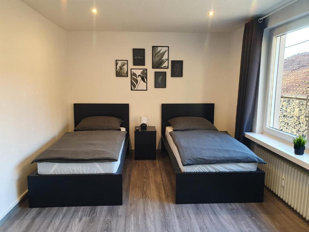 2 Betten in einem Schlafzimmer mit Fenster in der Unterkunft Ferienwohnung am See in Borken
