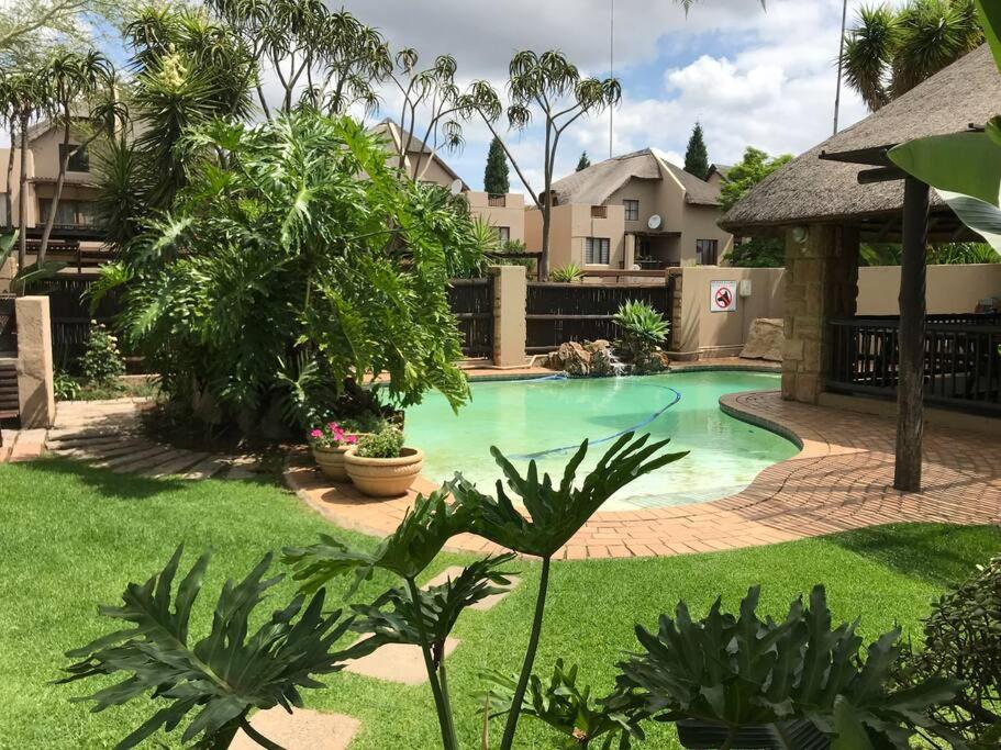 a swimming pool in the middle of a yard at Perfectly located beauty in secure Estate in Sandton