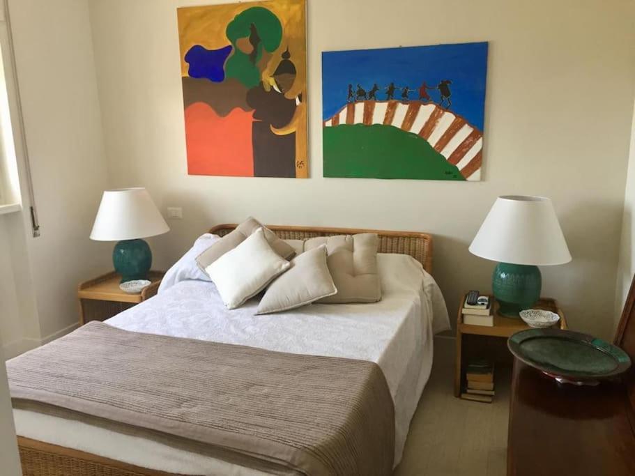 una camera con un letto con due tavoli e due lampade di Appartamento signorile, luminosissima vista mare a Fregene