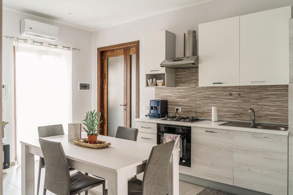 a kitchen with a white table and chairs in a room at Delia case vacanza in Fiumefreddo di Sicilia