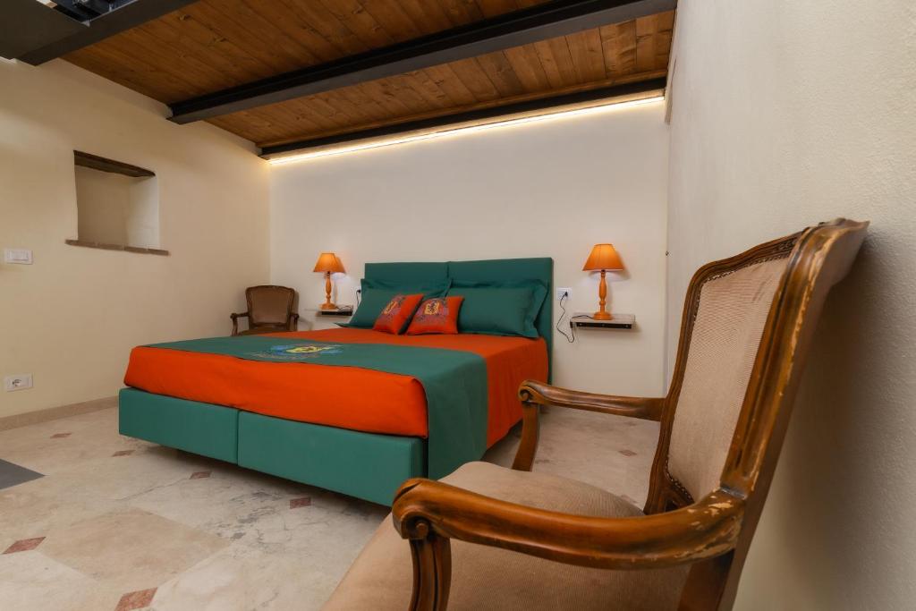 1 dormitorio con 1 cama y 1 silla en IBibiena - SUITE CECCO E MEA en Bibbiena