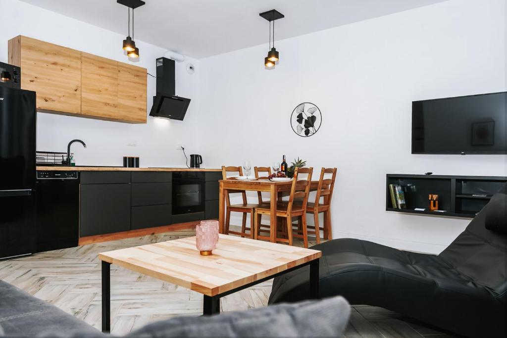 a living room with a table and a kitchen at Mazurski Apartament in Szczytno