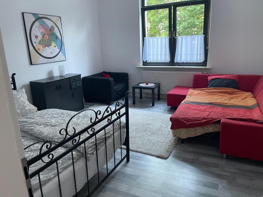 ein Schlafzimmer mit einem Bett und einem Sofa in der Unterkunft Ferienwohnung Zentral in Kassel in Kassel