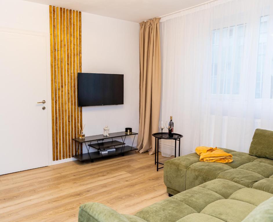 a living room with a couch and a flat screen tv at Urban Nest in Zalău