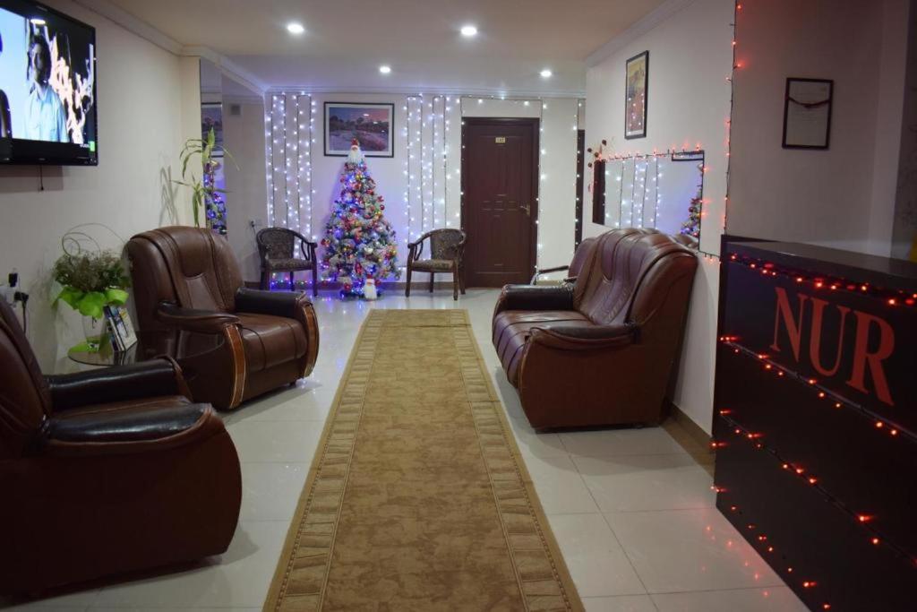 poczekalnia z choinką świąteczną i skórzanymi krzesłami w obiekcie Nur Hotel w Erywaniu