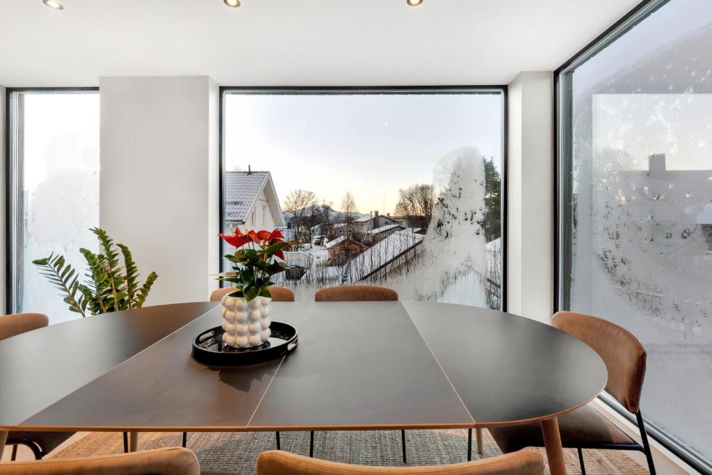 a dining room with a table and a large window at Osiris Home in Tromsø