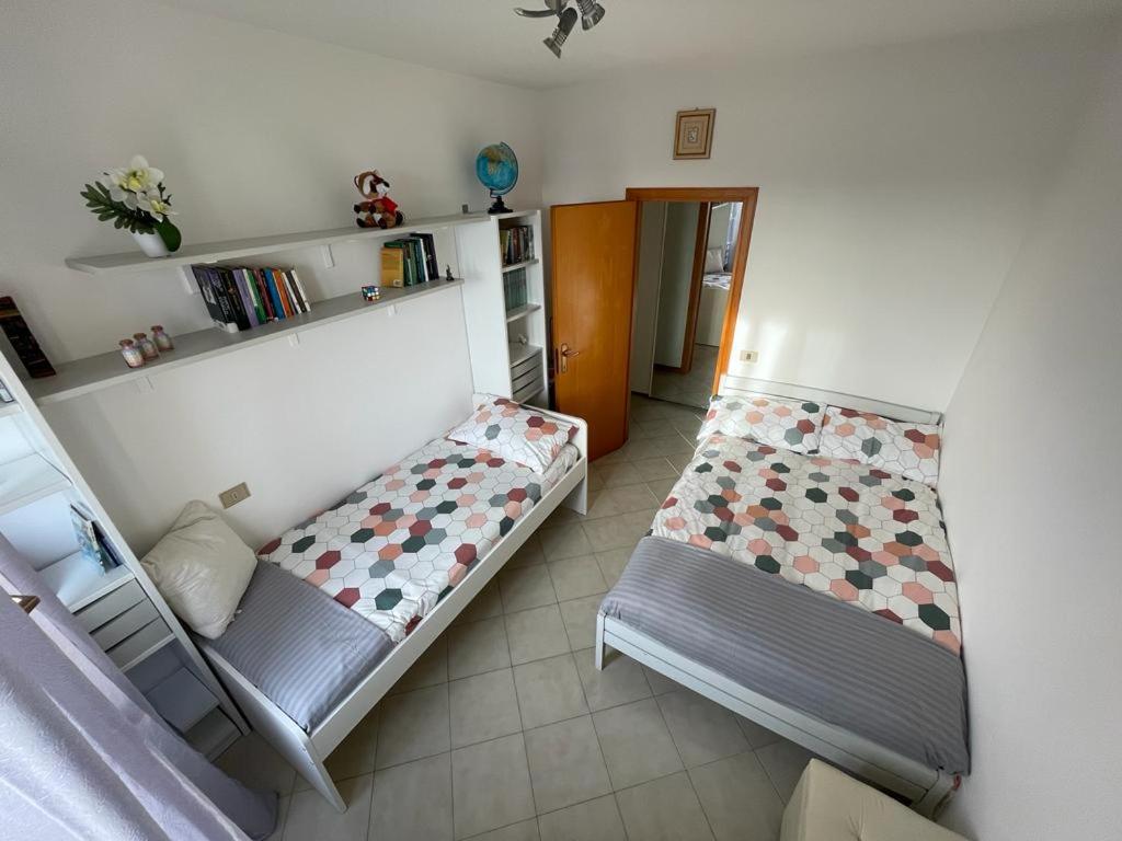 a bedroom with two beds and a book shelf at Da Roberto in Falconara Marittima
