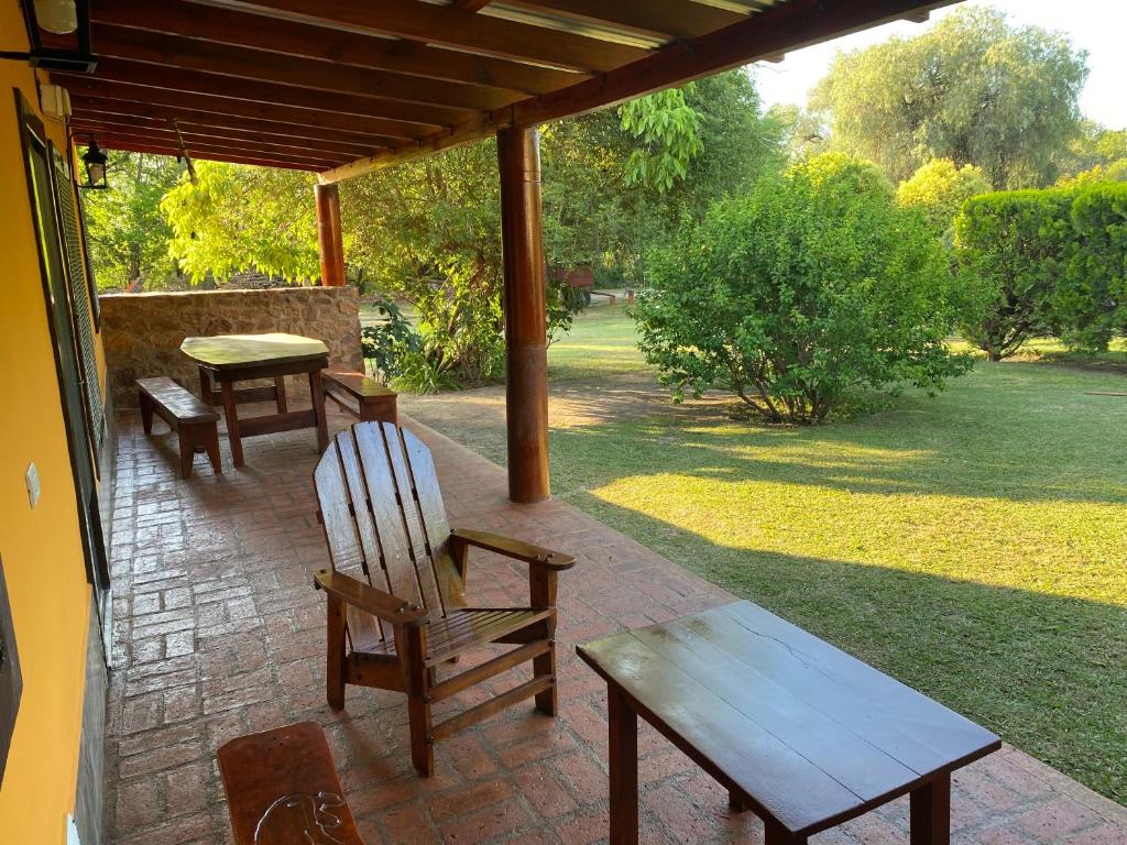 a patio with two wooden chairs and a table at Cabaña Emilia in San Javier