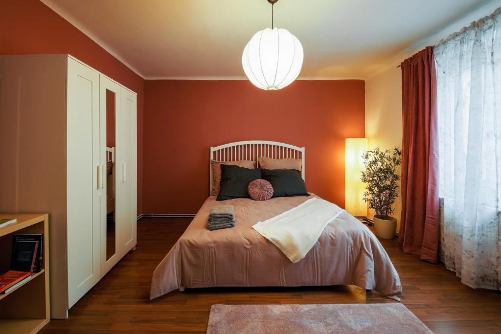 a bedroom with a large bed with orange walls at Cosy apartment in great Location in Vienna