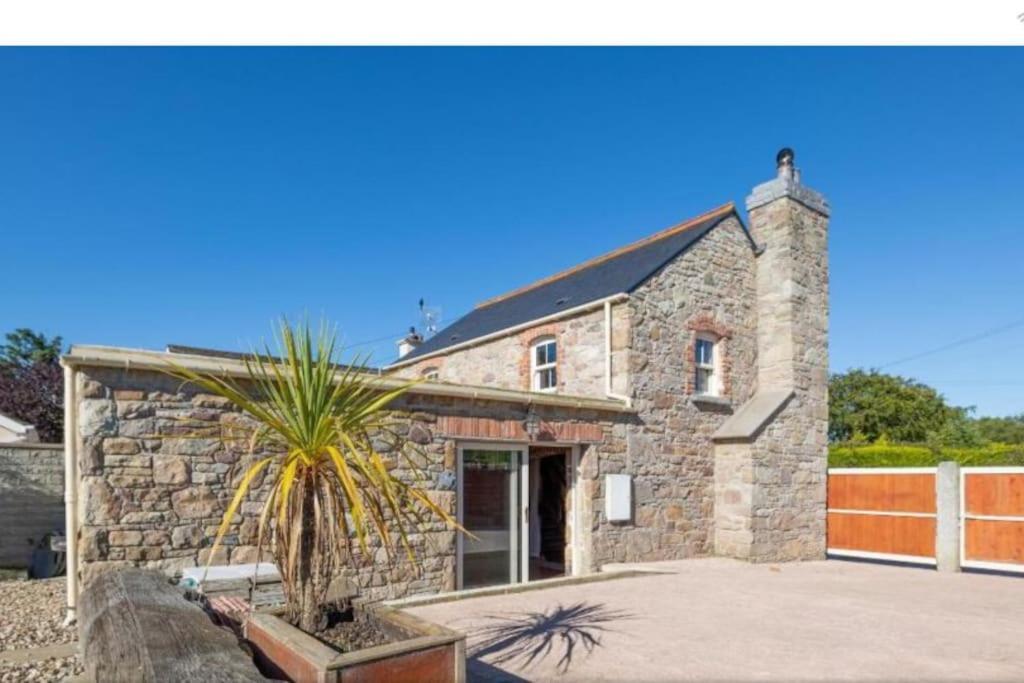 a stone house with a palm tree in front of it at 2 Bed Sandstone Residence in Newport