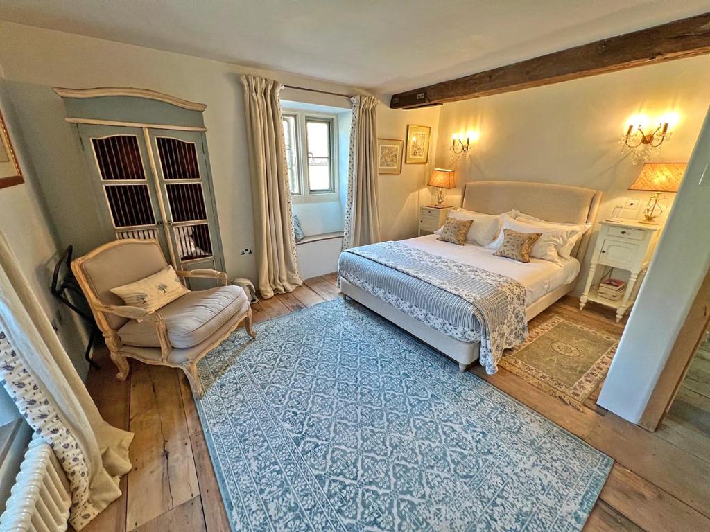 a bedroom with a bed and a chair at Brook House in Nunney