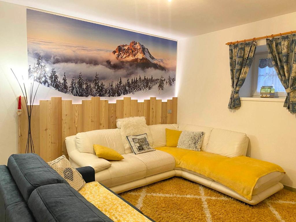 - un salon avec un canapé et un tableau mural dans l'établissement Appartamento Valmaor, à Predazzo