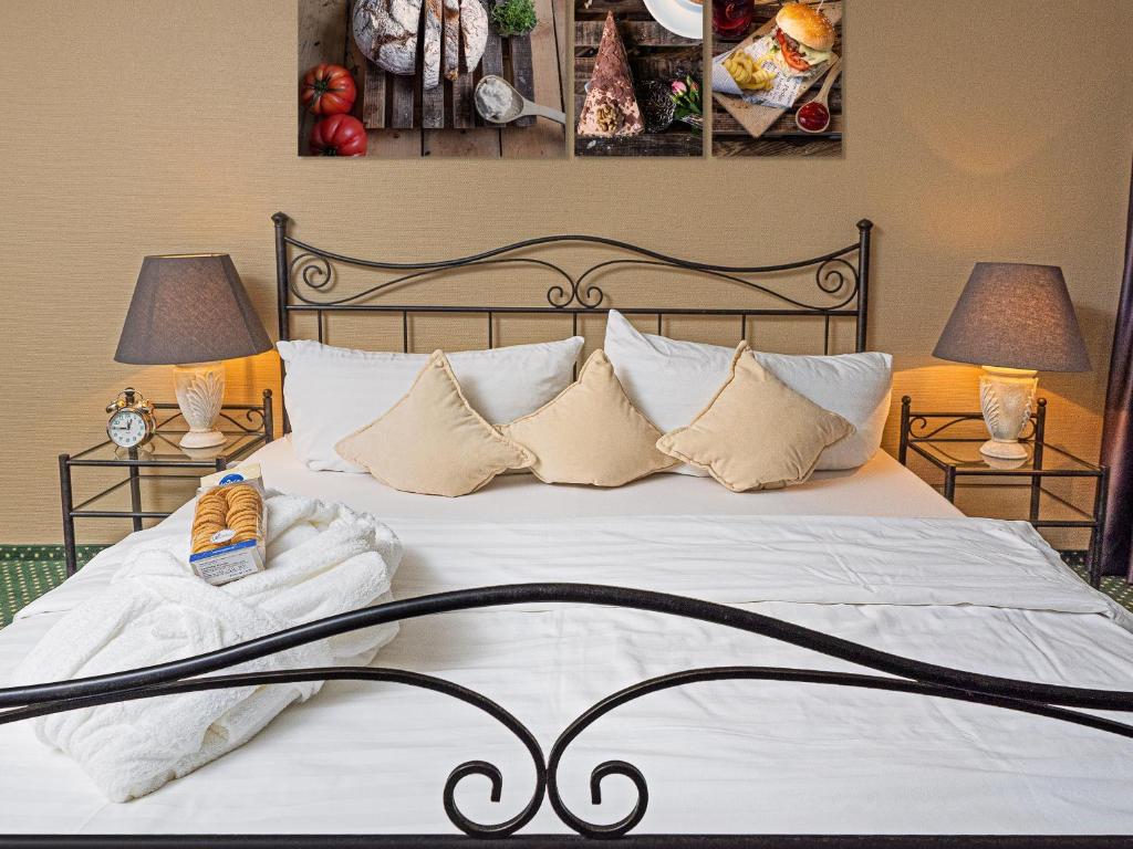 ein Schlafzimmer mit einem großen Bett mit weißer Bettwäsche und Kissen in der Unterkunft Hotel Rhyhof in Frauenfeld