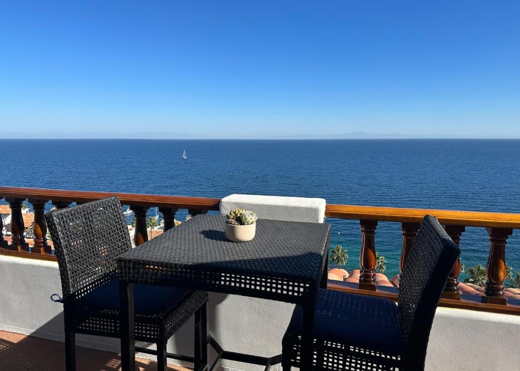 a table and chairs on a balcony overlooking the ocean at Premium Ocean Corner Unit, Fireplace, Golf Cart, 21 Steps from Top in Avalon