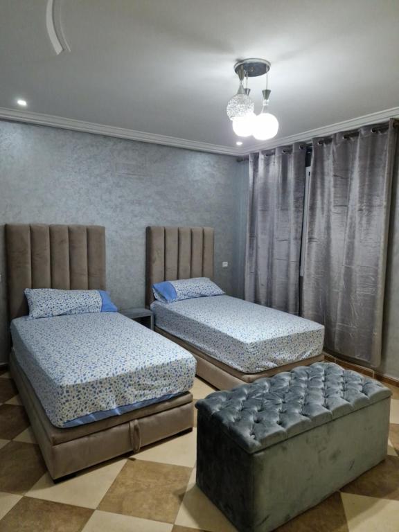 sypialnia z 2 łóżkami i kanapą w obiekcie RESIDENCE LA CORNICH w mieście Nador
