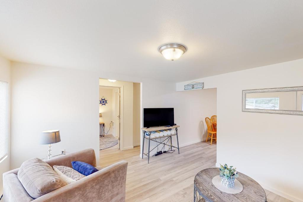 a living room with a couch and a television at DnA Tiny beach House in Reedsport