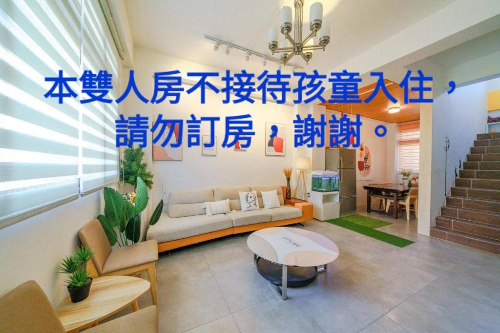 a living room with blue writing on the wall at Field Trail Homestay in Jiaoxi