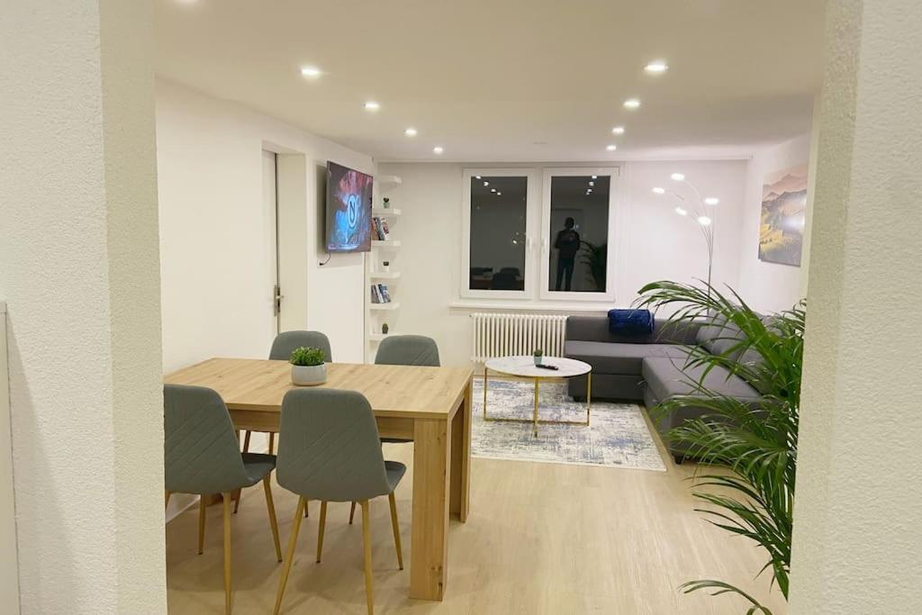 - un salon avec une table et des chaises en bois dans l'établissement Grubenmann Appartements Herisau, à Herisau