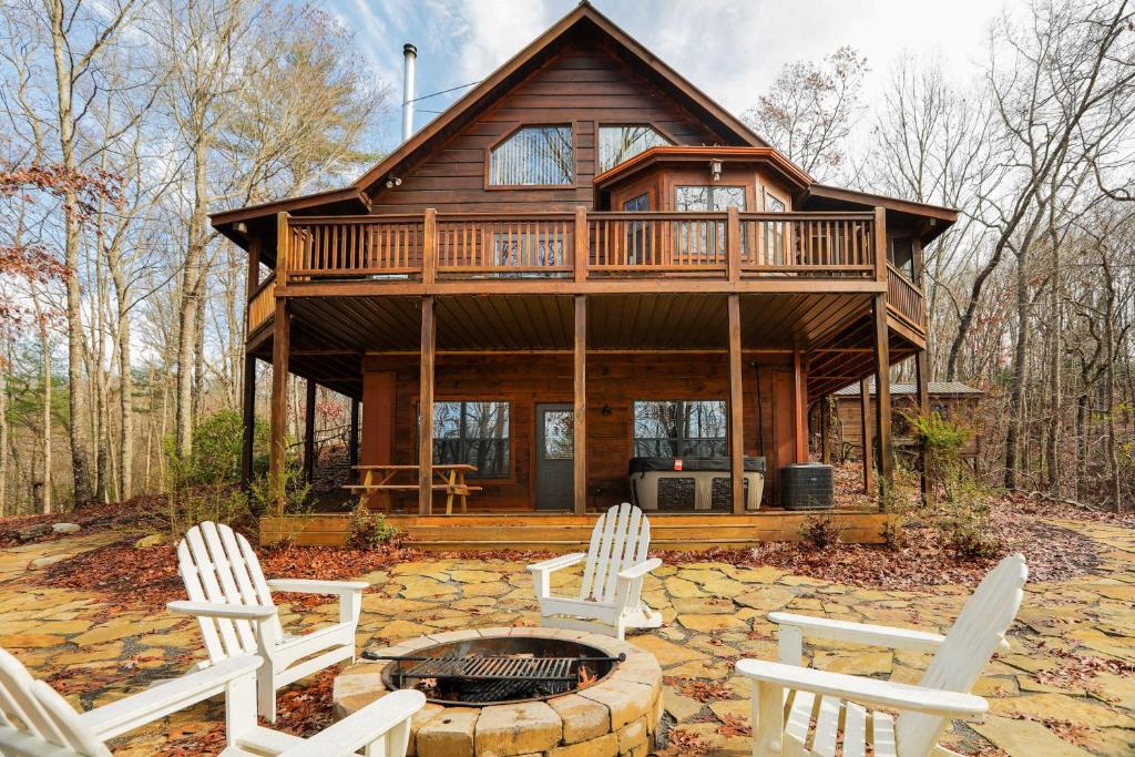 a log cabin with chairs and a fire pit at Bear Naked Bungalow in Blue Ridge