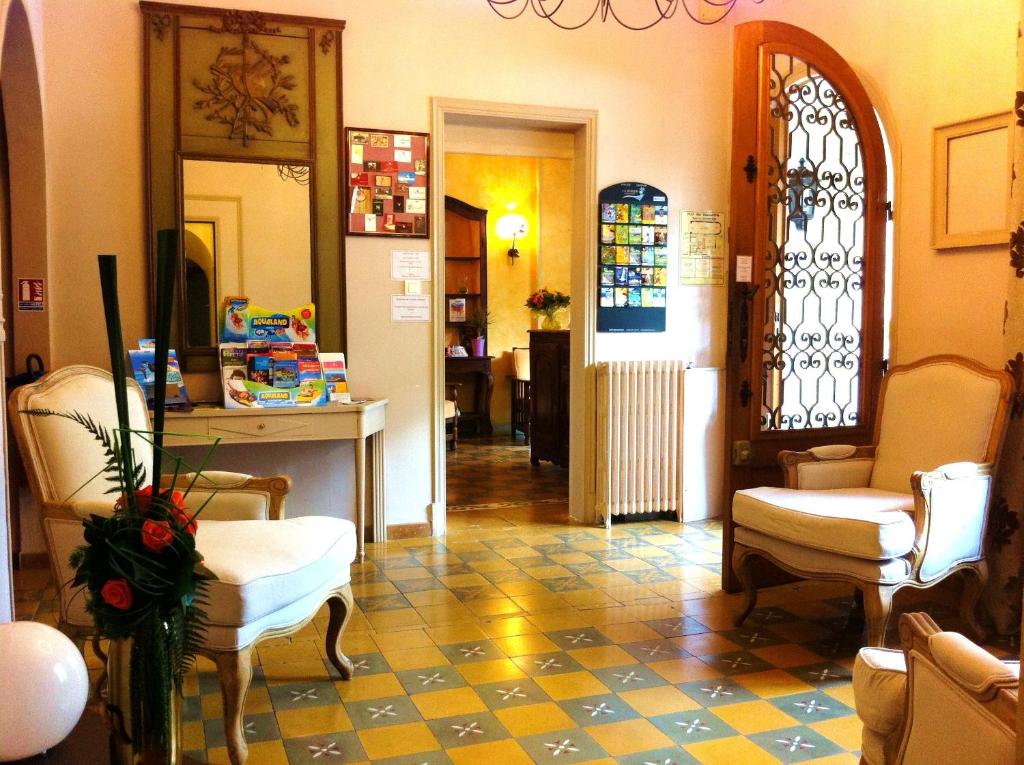 a living room with chairs and a mirror and a hallway at La Marjolaine in Juan-les-Pins