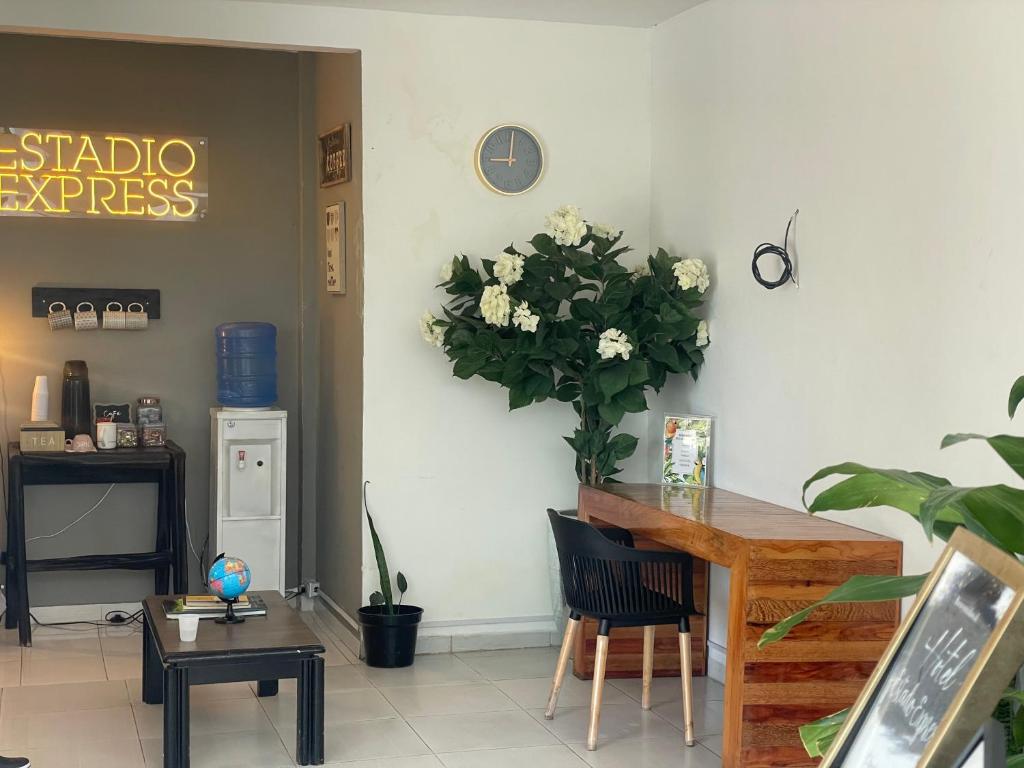 une chambre avec une table et une plante sur le mur dans l'établissement Hotel Estadio Exprés, à Leticia