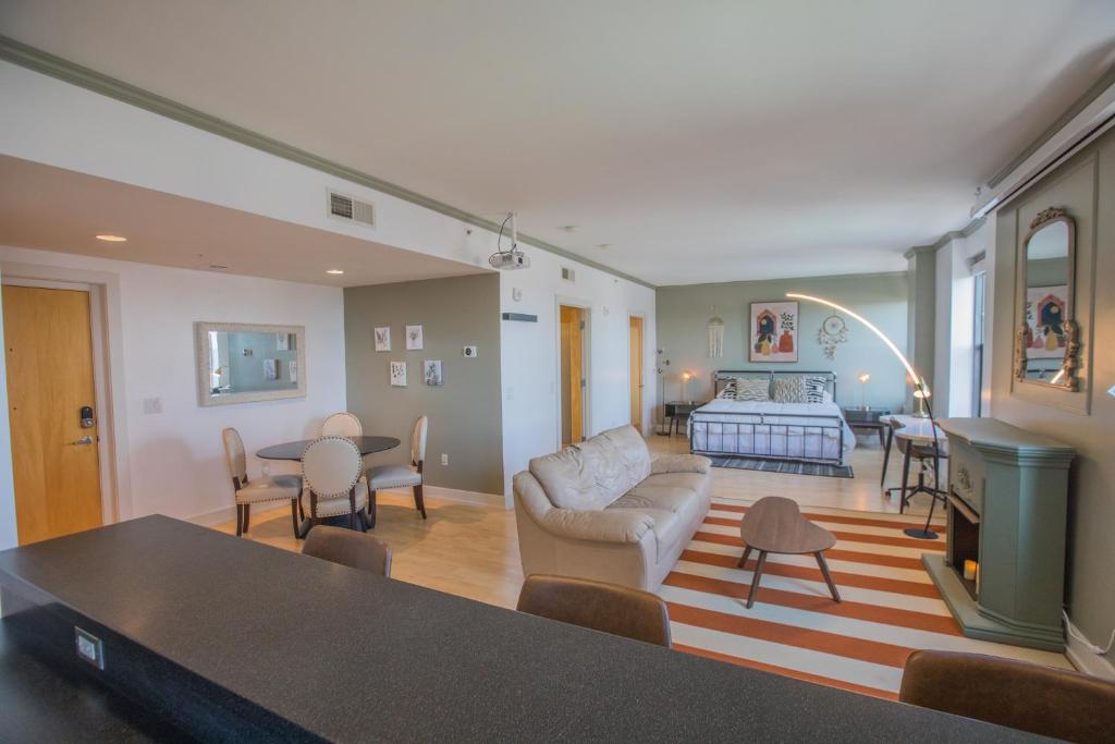 uma sala de estar com um sofá e uma mesa em Designer Downtown Condo Suite - Splendid View em Des Moines