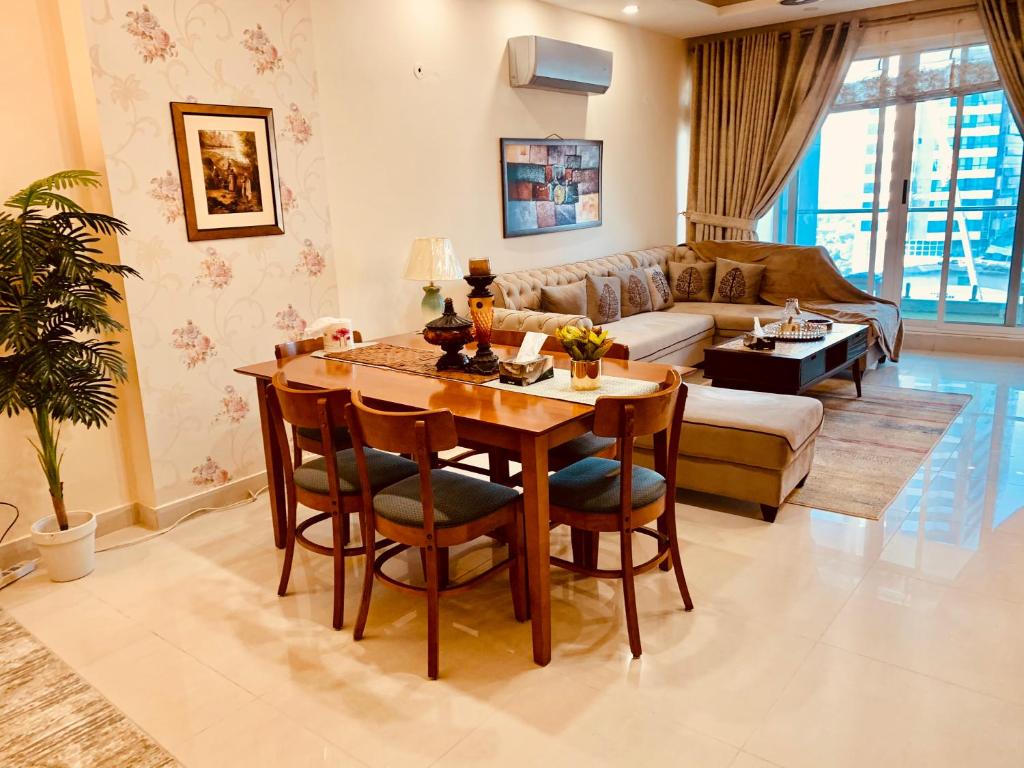sala de estar con mesa y sofá en Elysium Service Apartment 1203, en Islamabad