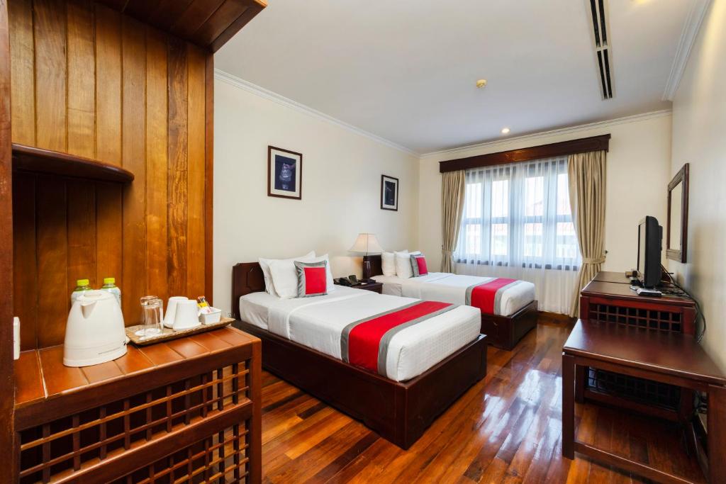 Postel nebo postele na pokoji v ubytování Saem Siemreap Hotel
