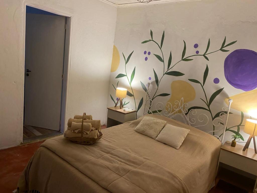 - une chambre avec un lit orné d'une fresque murale représentant des fleurs dans l'établissement Sitio Anju, à Atibaia