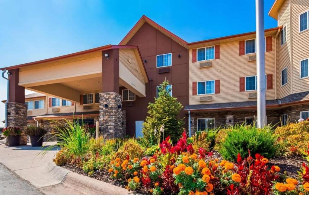 un edificio de apartamentos con flores delante en Old Mill Inn en Omaha