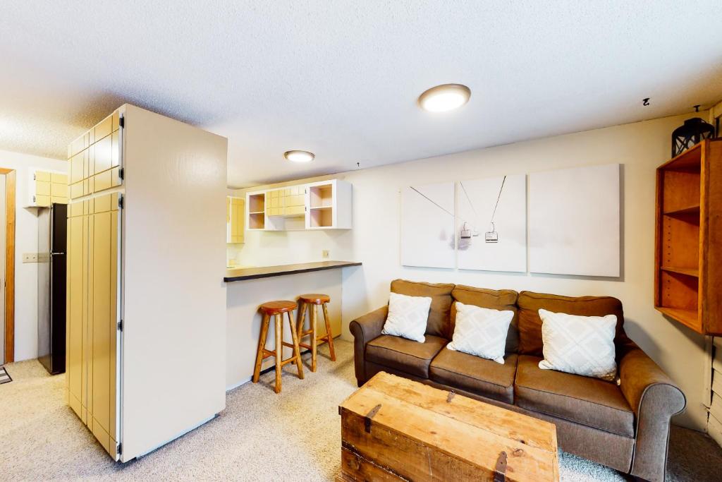 een woonkamer met een bank en een tafel bij Slope-Walk Condo in Sandpoint