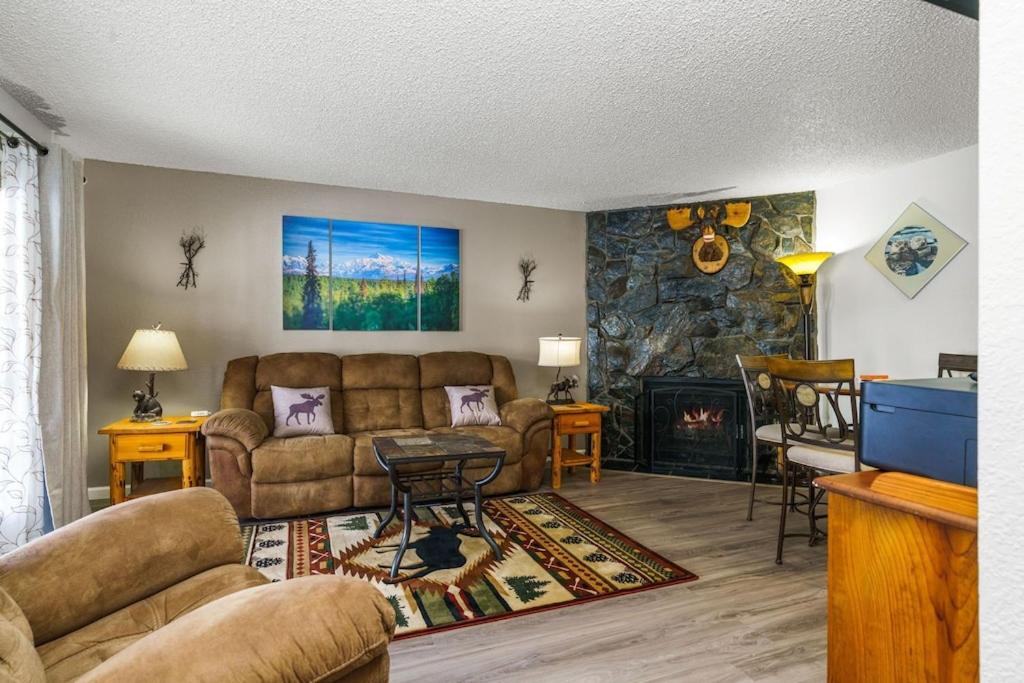 a living room with a couch and a fireplace at The Moose Crossing in Anchorage