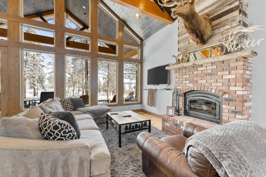 a living room with couches and a brick fireplace at Antoine Cabin in Chelan